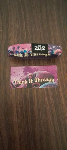 Customer's Think It Through bracelet with octopus design and matching card, laid flat on a dark wooden surface.