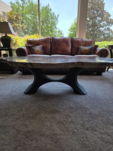 Customer's black Coffee Table Base 208 Haru supporting a rustic wooden table top in a living room.