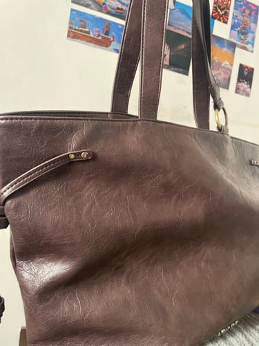 Reviewer's Cartera Tote Argolla Handle Tiritas in dark brown, showing the metal ring on the handle and side details.