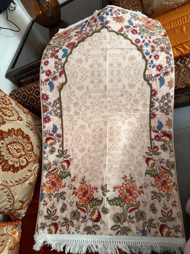 Customer's Barakah Padded Prayer Mat featuring cream fabric with intricate, floral printed patterns and fringe trim.