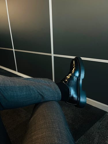 Customer's Lufiano Lace Up shoe in black and blue leather worn with gray trousers
