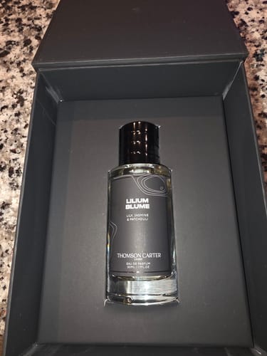 Customer's Lilium Blume perfume bottle centered in its open, dark gray box.