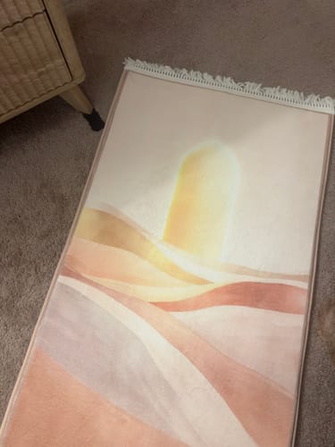 Customer's plush Anchor Mat in Desert Dawn pattern, laid on a carpeted floor next to a piece of furniture.
