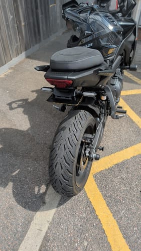 Customer's motorcycle with a cleanly installed black bracket, aftermarket plate light, and indicators.