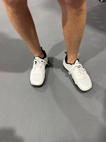 Customer's white CUURT Muuv court shoes being worn on a grey floor