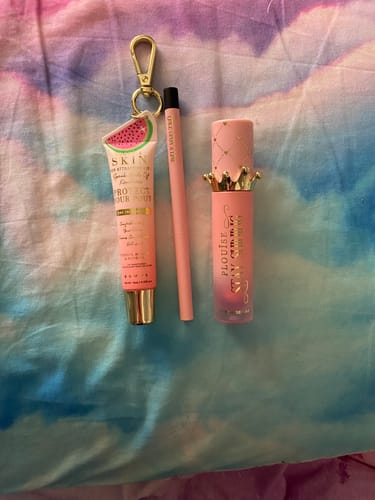 Customer's Welcome Mystery Bag items, including a pink lip tube, a thin pencil, and a crown-topped product.