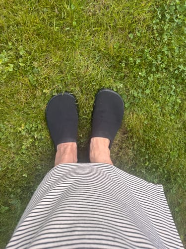 Customer's black Vaistoa Lempeä 3 slip-on kengät nurmikolla kuvattuna ylhäältä päin.