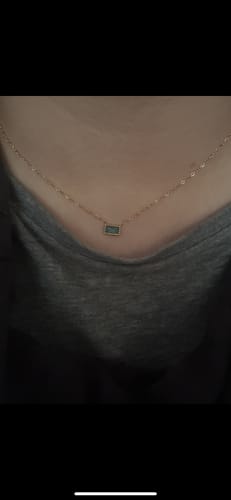 Customer's Baguette Birthstone Necklace with a rectangular blue crystal pendant worn on a thin chain