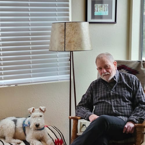 Customer's Eucalyptus Lyocell Compression Socks worn by a person sitting in a chair with their pet dog.