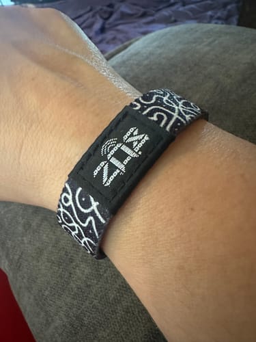 Reviewer's Believe In Yourself bracelet, featuring a black and white patterned band with a central tag on a wrist.