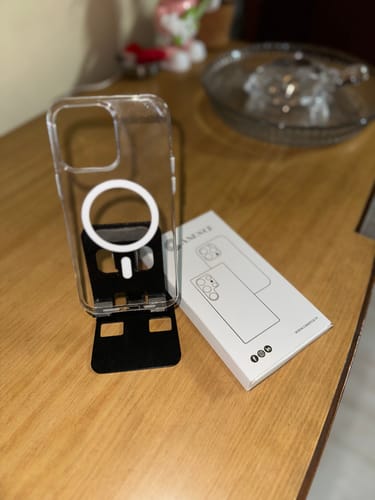 Customer's Anti Yellow Magsafe Clear Case for iPhone 14 Pro Max displayed on a stand next to its original white packaging.