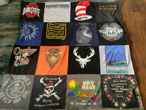 Reviewer's Project Repat T-Shirt Quilt featuring a colorful collage of various t-shirt graphics on a soft surface.