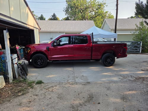 Customer's red Ford F150 truck parked on a driveway after installing the front leveling lift kit.