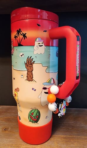 Customer's 40oz Thicc Buddy cup decorated with spooky beach designs and a beaded keychain on its red handle.