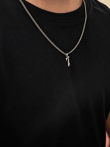 Customer's Lucky 7 Pendant on a chain, worn around a person's neck against a black shirt.