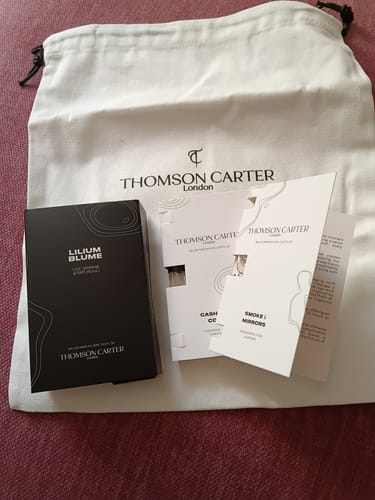 Customer's Lilium Blume fragrance, perfume testers, and branded cloth bag on a textured surface.