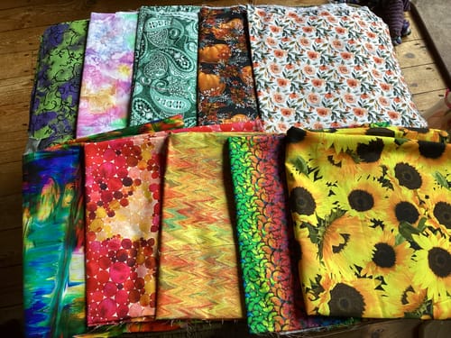 Customer's Cotton Mystery Remnant Bundle showing a collection of colorful patterned cotton fabric pieces.