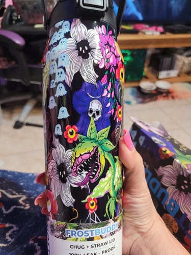Reviewer's Bottle Buddy in Toxic Bloom print, featuring colorful floral and skull pattern, held in hand.