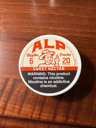 Customer's Sweet Nectar nicotine pouch tin resting on a wood surface.