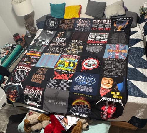 Customer's Project Repat T-Shirt Quilt featuring various band logo squares, laid out on a bed.