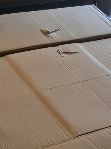Customer's Shipping Protection cardboard delivery boxes with small punctures on the surface.