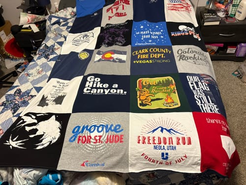 Customer's Project Repat T-Shirt Quilt featuring a patchwork of colorful cotton t-shirt squares on a bed.