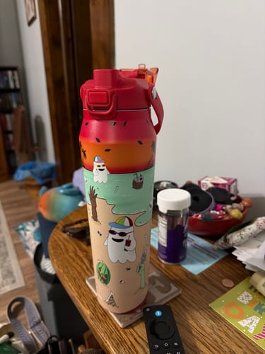 Customer's Bottle Buddy water bottle with a colorful summer-themed ghost print standing on a wooden surface.
