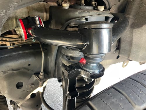Customer's black 2-4" Upper Control Arms installed on a Toyota vehicle, showing the ball joint and bushings.