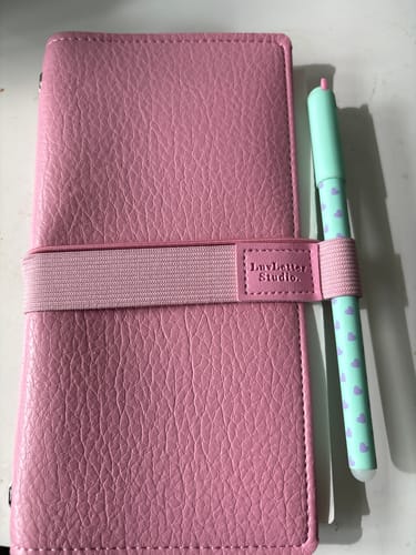 Customer's pink Sugar Sweet journal with a textured cover, elastic strap, and a patterned pen.