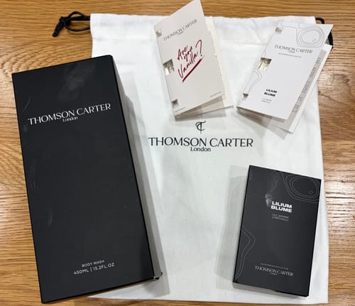 Customer's Lilium Blume fragrance, body wash, and brand cards laid out on a white cloth bag.