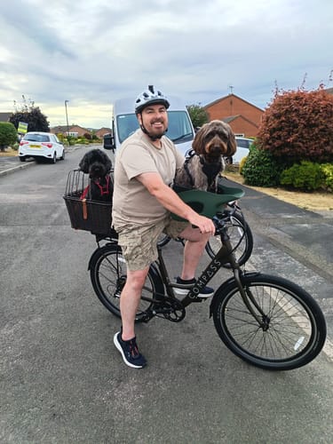 Customer's Kvisp Dog Bike Carrier mounted on a bicycle with a dog sitting in it and another dog in a back basket.