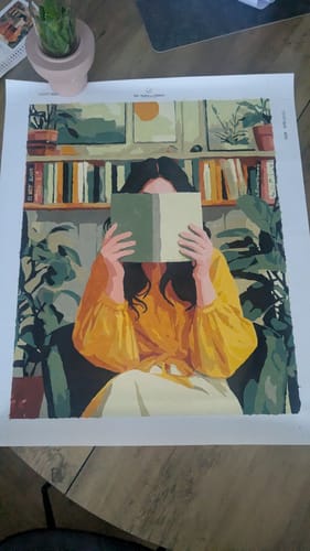 Customer's fertig gemaltes Malen nach Zahlen Bild Versteckt zwischen den Seiten, das eine Frau mit Buch zeigt.