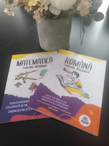 Customer's Pachet Evaluare Națională, conținând culegerile de Matematică și Română, așezate lângă un ghiveci cu flori.