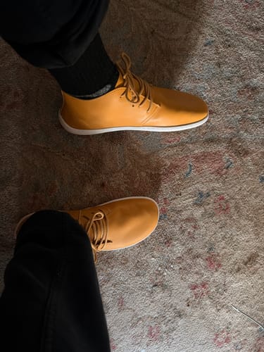 Customer's yellow Noble Ⅰ barefoot dress shoes worn on carpet, viewed from above.