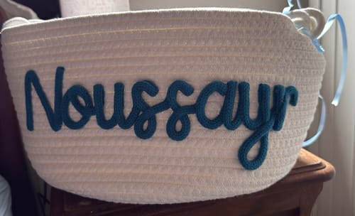 Customer's gift basket with white woven rope and the name Noussayr spelled out in dark blue script.