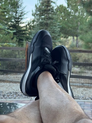 Customer's CUURT Muuv court shoes being worn outdoors with legs crossed