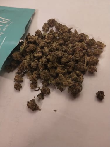 Customer's 1 Oz Cheap THCA Small Buds, a large pile of compact green flower buds next to a teal product bag.