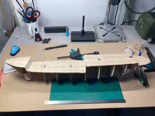 Customer's Endurance wooden ship model in progress on a workspace with tools and assembly parts.