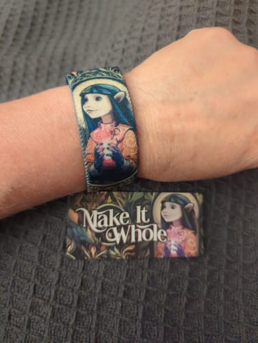 Customer's Make It Whole bracelet featuring a character print worn on their wrist with a matching design card below.