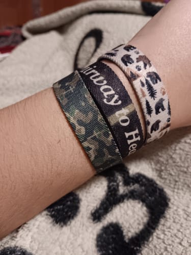 Customer's wrist wearing three patterned elastic bracelets including the Full Armor of God Bible Verse Bracelet.