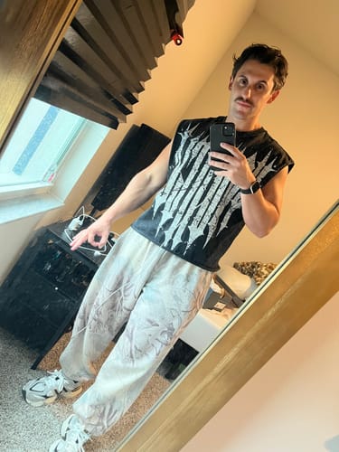Reviewer's 3021 Revenge Crop Cut-Offs in black with distressed logo, worn with patterned pants in a mirror selfie