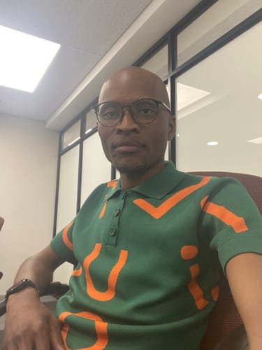 Customer's green knit top with orange pattern, worn by a reviewer in an office setting.