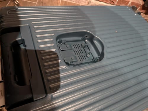 Customer's NOBL e-Gift Card suitcase, close-up showing broken plastic cup holder attachment.