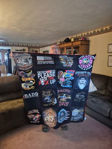 Customer holding up a custom Project Repat T-Shirt Quilt featuring various graphic t-shirt panels.