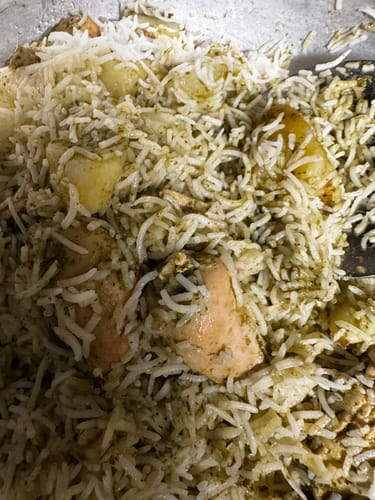 Customer's Halal Whole Chicken cooked with rice and potatoes in a pan.