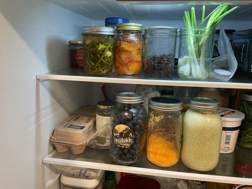 Customer's Mason Genie Vacuum Sealer Kit used to seal various food items in glass mason jars inside a refrigerator.