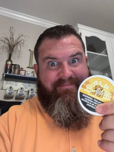 Customer holding a can of Drifters Island Peach nicotine pouches while smiling broadly.