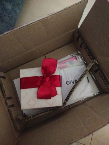 Customer's packaging for the Silver Glittering Ring, showing the gift box with a red bow inside the delivery carton.