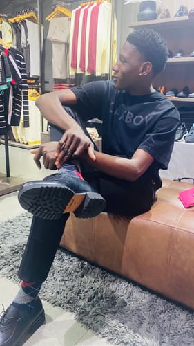 Customer's Lufiano Lace up shoes in black, worn while sitting in a clothing store.