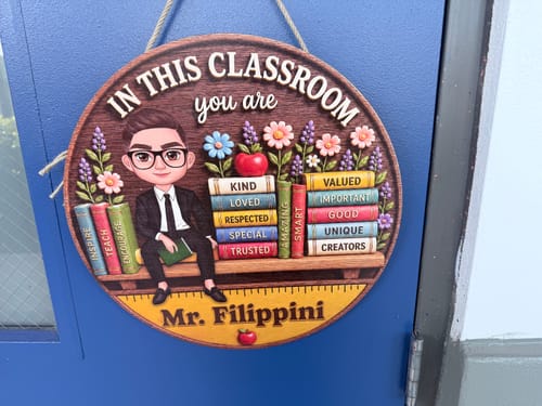 Customer's personalized Mr. Filippini teacher wooden door sign hanging on a blue classroom door.